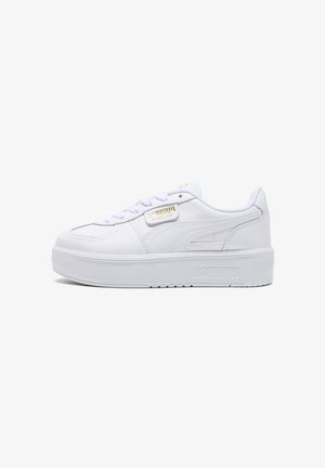White platform sneakers made of smooth leather, featuring lace-up design, textured sole, and gold branding on the side for a sleek look.