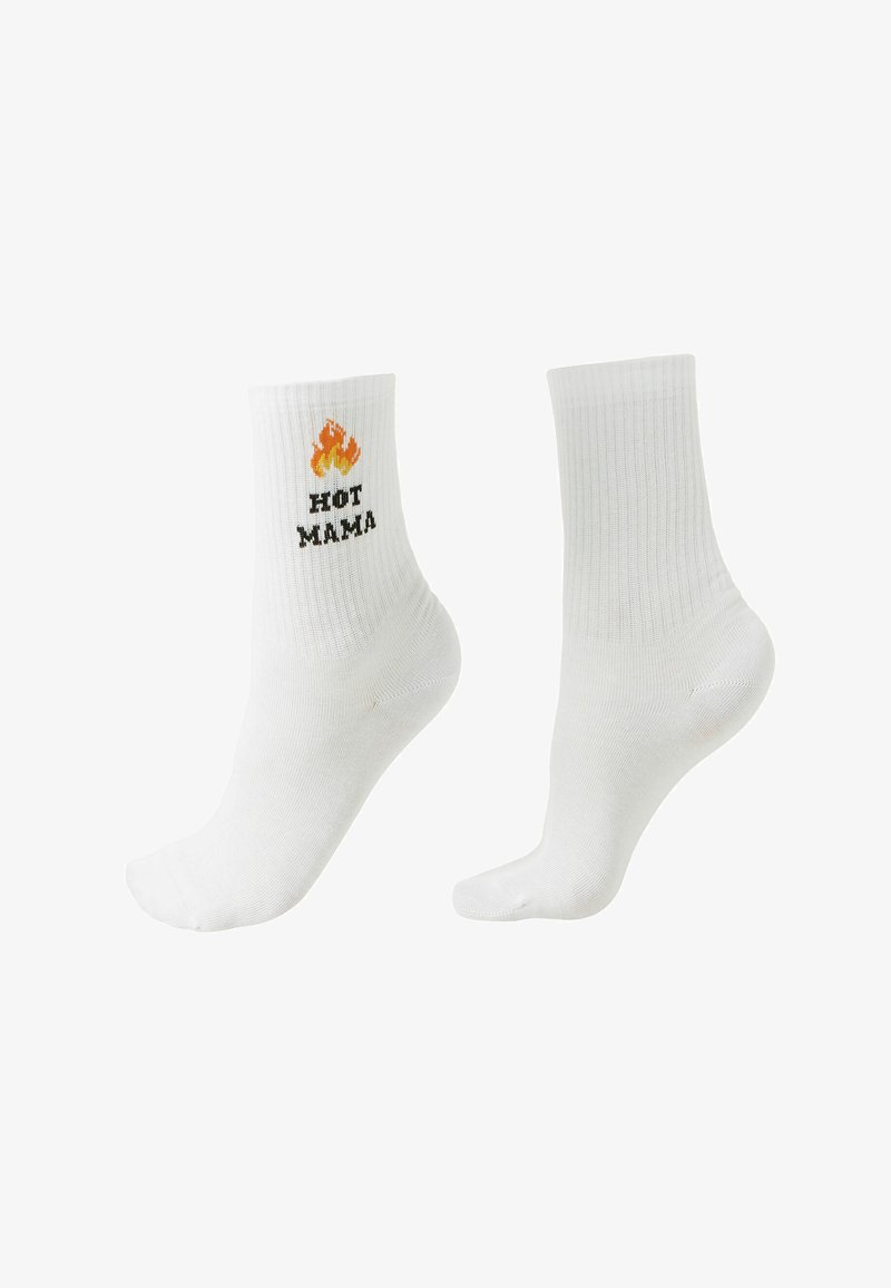 Pár bílých ponožek do kotníků, jedna s plamenem a nápisem „HOT MAMA“ na kotníku, druhá ponožka čistě bílá.