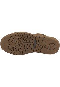 Suela de goma marrón de un zapato con un patrón de banda de rodadura en zigzag, textura suave y el nombre de la marca en relieve con indicación de tamaño.
