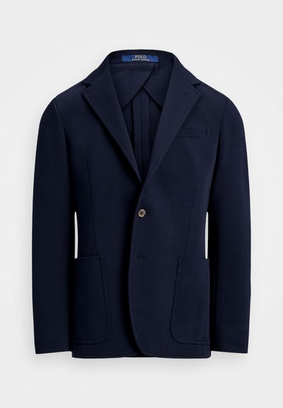 Granatowy blezer z gładkiego materiału, z klapami typu notch, dwoma przednimi kieszeniami i zapięciem na jeden guzik o lekkim połysku.