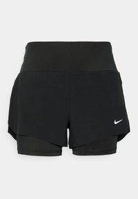 Pantalones cortos deportivos negros con un diseño en capas que incluye un short interior y una superposición exterior, fabricados con un tejido ligero y elástico.