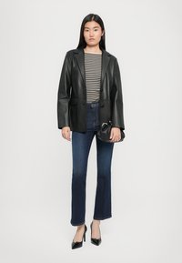 Must have mustang nahk blazer, triibuline särk, tume sinine laiekäistega teksapüksid, mustad kõrged kontsad, hoiab väikeses mustas käekotis. Lihtne disain ja sobivus.