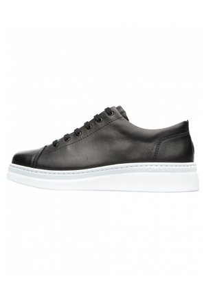 Black leather sneaker with a smooth texture, featuring a white rubber sole, six eyelets, and minimalistic design without visible branding.