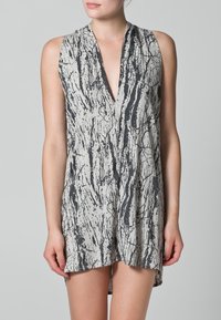 Vestido sin mangas en gris claro con un patrón abstracto oscuro. Presenta un escote en V profundo y una silueta fluida, hecho de una tela suave y ligera.