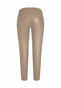 Leggings in finta pelle beige con vestibilità slim, dotati di due tasche posteriori e dettagli cuciti discreti lungo le gambe. Texture morbida.