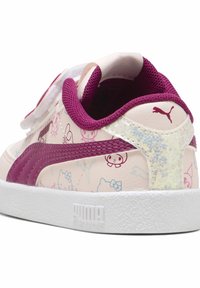 Puma-sneakers med en ljusrosa syntetisk ovandel med lila detaljer, en texturerad vit sula och en glansig iriserande häldekoration.