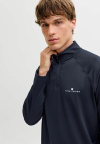 Mereväe poolt tõmmatud nööbiga pullover sujuvast atleetlikust kangast. Rinnal on logo ja raglanvarrukad, mis võimaldavad liikumisvabadust.
