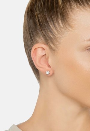 Silver stud earrings featuring a round, clear crystal in the center, showcasing a smooth texture and classic design.