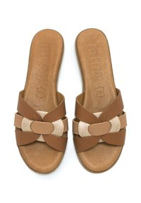 Ciabatte in pelle marrone con fasce incrociate, dotate di un accento dorato circolare. Sottopiede testurizzato per il comfort. Suola piatta, design con retro aperto.