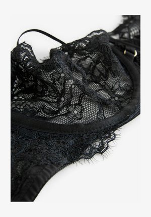 Lencería de encaje negro con un patrón floral, textura suave y diseño semitransparente con bordes elásticos y detalles delicados.