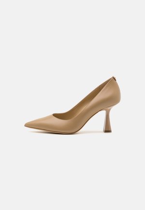 Beige patentlæder stilet med spids tå, et strømlinet design og en karakteristisk geometrisk hæl. Glat overflade, minimal syning.