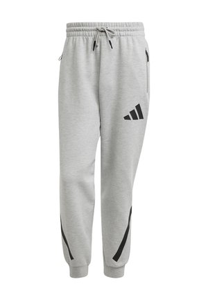 Grå sweatpants lavet af bomuld med elastisk talje, snor, sidelommer og sorte accentstriber langs siderne. Sort logo på låret.