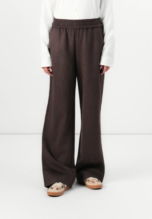 Wijde broek van zacht, donkerbruin materiaal met een elastische tailleband. De broek heeft een gladde textuur en minimale stikseldetails.