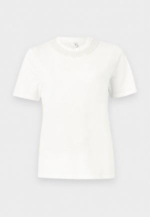 Fehér rövid ujjú felső kerek nyakkivágással, amely texturált gyöngydíszítéssel van ellátva.