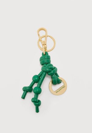 Guldnøglering med grønne sammenknyttede læderkvaster og en gylden cirkulær vedhæng med indgraveret "VALENTINO" på hvid baggrund.