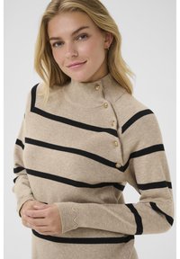 Beiger Pullover mit schwarzen horizontalen Streifen, hohem Kragen, geripptem Textur und vier goldenen Knöpfen an der linken Schulter. Lange Ärmel.