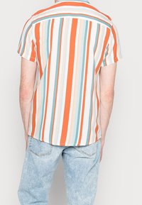 Korte mouwen shirt met verticale strepen in oranje, lichtblauw en crème. Lichtgewicht stof met een ontspannen pasvorm en een subtiele kraag.