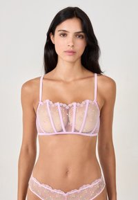 Pink mesh bra with floral embroidery, scalloped edges, and thin adjustable straps. Features structured panels and delicate lace accents.