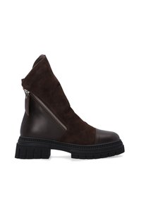 Bruine enkellaars met suède bovenwerk, leren accenten, zijrits en dikke zwarte rubberen zool. Voorzien van een semi-matte afwerking en een gestructureerd ontwerp.