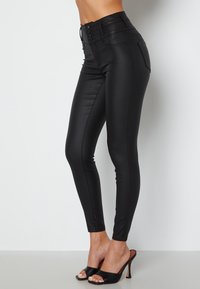 Hoge taille zwarte faux leren leggings met een gladde textuur, knoopdetails bij de taille en een slim-fit ontwerp.