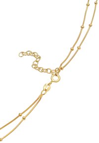 Collana in metallo dorato con fini anelli, piccoli accenti sferici e chiusura a moschettone. Presenta una catena di estensione regolabile.