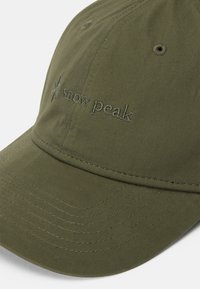Olive green baseball cap made of cotton with an embroidered "snow peak" logo. Features a curved visor and visible stitching details.
