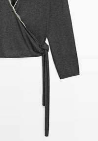 Vêtement enveloppant à manches longues gris foncé avec un nœud latéral noué et des détails effilochés le long de l'encolure et de l'ouverture avant.