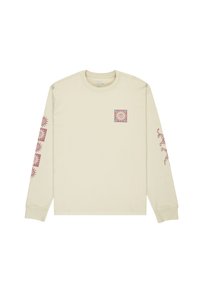 Camicia a maniche lunghe di colore beige chiaro, realizzata in cotone, con una grafica di un sole quadrato viola sul petto e motivi di sole ripetuti sulle maniche.