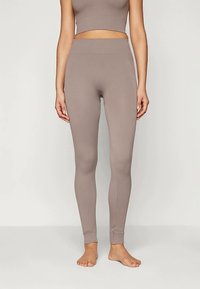 Ριγέ, ανοιχτό καφέ κολάν με ψηλή μέση. Μαλακό, ελαστικό ύφασμα και εφαρμοστό σχέδιο. Ιδανικό για αθλητική ένδυση ή casual χρήση.