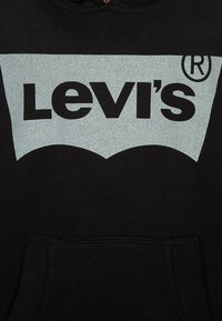 Felpa nera in cotone con un logo grafico grigio di Levi's sul fronte. Presenta una tasca a marsupio e un cappuccio con cordino.