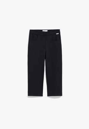 Schwarze Capri-Leggings aus dehnbarem Stoff. Mit einem flachen Bund und zwei vorderen Taschen. Glatte Textur ohne sichtbare Muster.