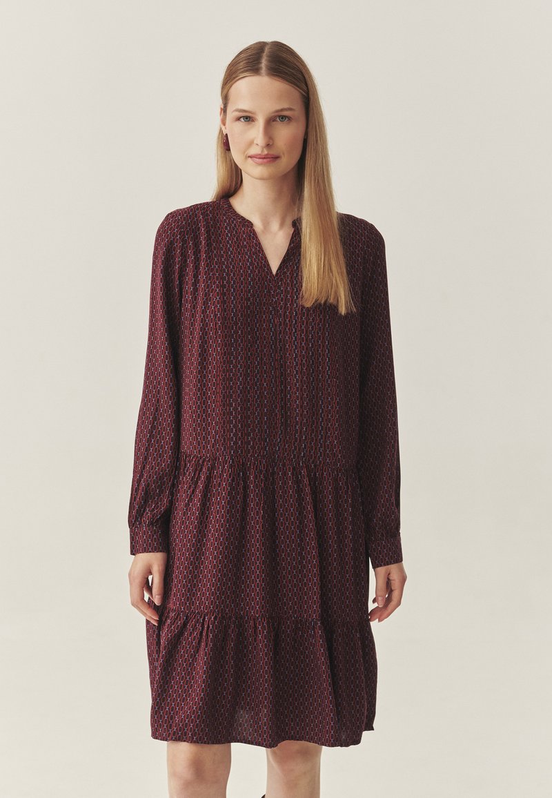 Bordo kleit pikkade varrukatega, V-dekoltee, kihiline seelik ja geomeetrilise mustriga tekstuur üle kogu pinna. Valmistatud kerge kangaga.