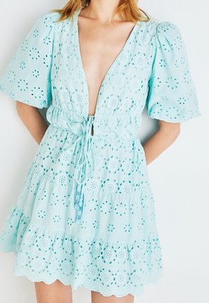 Světlomodré šaty s dírkovaným vzorem, hlubokým výstřihem do V, nabíranými rukávy, elastickým pasem se šňůrkou a vrstveným volánovým lemem.