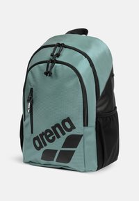 Zaino turchese chiaro con accenti neri, dotato di scomparti con cerniera, tessuto strutturato e un logo nero prominente sulla parte frontale.