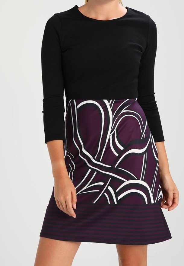 Haut à manches longues noir avec une jupe violette ornée de motifs abstraits blancs et de rayures, présentant une coupe ajustée et une texture lisse.