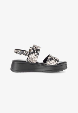 Sandalo platform nero con cinturini in stampa serpente beige e nera, uno sopra le dita dei piedi e uno con fibbia attorno alla caviglia, suola piatta.