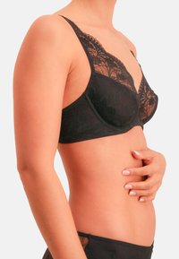 Schwarzer Spitzen-BH mit floralem Muster, Bügelunterstützung, verstellbaren Trägern und transparentem Mesh-Design. Glatter Stoff mit kontrastierenden Details.