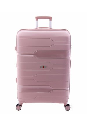 Valigia rigida di colore rosa soft, caratterizzata da un design elegante con texture ondulate, una maniglia retrattile e quattro ruote per una facile mobilità.