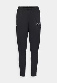 Sorte treningsbukser med en smal design, elastisk midjebånd, sidelommer og en hvit Nike-logo på øvre venstre bein. Glatt tekstur.