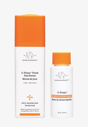 Drunk Elephant C-Firma Fresh Day Serum und Liquid Serum Base Flaschen mit orangen Kappen auf weißem Hintergrund.