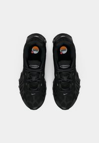 Um par de ténis Nike Air Max pretos com parte superior em malha, design de atacadores e amortecimento de ar visível, vistos de cima sobre um fundo branco.