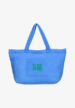 Sac fourre-tout en tissu bleu avec deux poignées et une poche avant ornée d'un logo Billabong vert et d'un motif floral.
