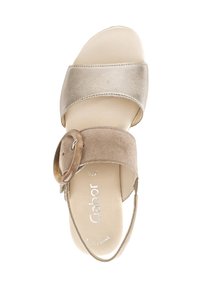 Lichtbeige sandalen met twee brede banden, waarvan de ene van glad materiaal is en de andere van gestructureerd suede, met een ronde gespdetail.