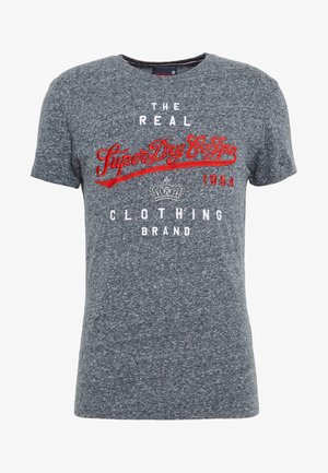 Szara koszulka z krótkim rękawem i okrągłym dekoltem. Posiada czerwony haftowany napis "SuperDry Co." oraz logo korony. Miękki, teksturowany materiał.