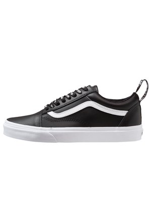 Black low-top sneaker with white side stripe, white rubber sole, black laces with white text, and a pull tab at the heel.