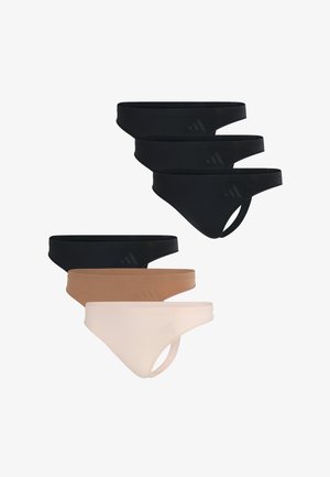 Weißes, geripptes Tanktop mit Rundhalsausschnitt, kombiniert mit schwarzen Slips mit dezentem Logo. Der Stoff wirkt dehnbar und figurbetont.