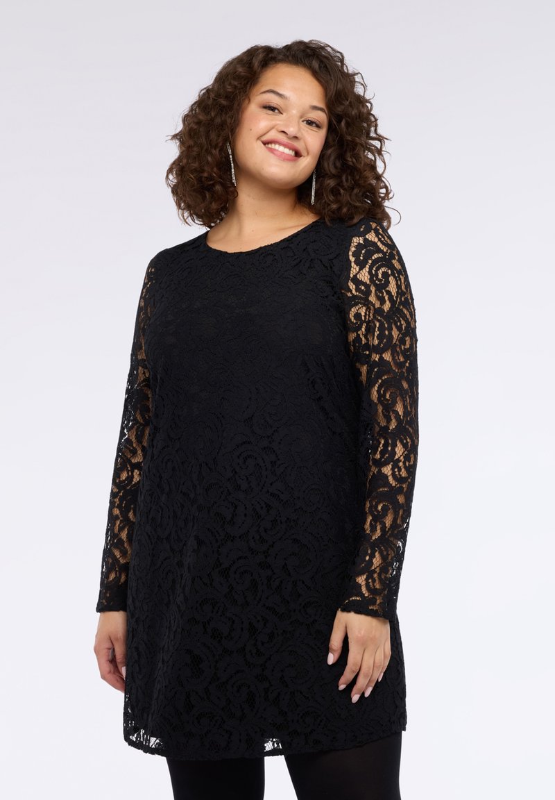 Schwarzes Spitzenkleid mit langen, durchsichtigen Ärmeln, verziert mit filigranen Wirbelmustern. A-Linien-Silhouette, runder Ausschnitt und knielanger Saum.