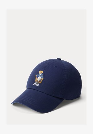 Marineblauwe baseballpet met een geborduurd teddybeertje dat een blauwe blazer, witte broek en het woord "POLO" onder de beer draagt.