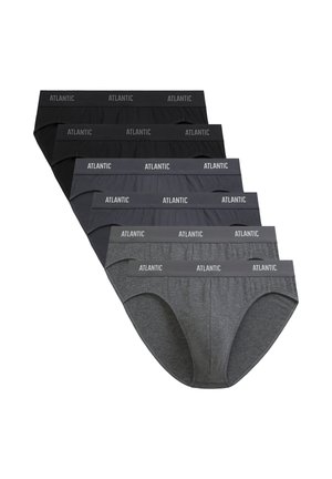 Wytrenowany mężczyzna o jasnobrązowych włosach, ubrany w czarne slipy marki Atlantic, stoi na jednolitym jasnym tle, zwrócony twarzą do przodu.