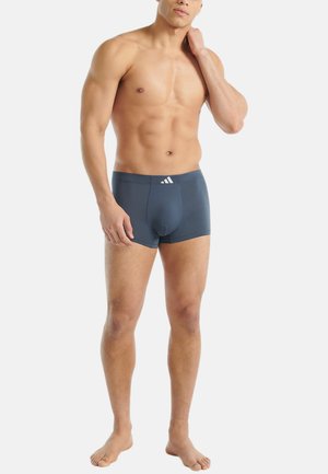 Dunkelblaue Boxer-Briefs aus einem glatten, elastischen Stoff. Sie verfügen über ein tailliertes Design und ein weißes Logo am Bund.
